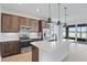 Eat-in kitchen with stainless steel appliances and kitchen island with sink and backyard lake view at 276 Hilltop Bloom Loop, Haines City, FL 33844