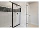 Tiled shower with a glass door and black trim, complemented by a modern black shower head at 276 Hilltop Bloom Loop, Haines City, FL 33844