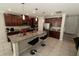 Well-lit kitchen featuring dark cabinets, a center island with bar stools, and stainless steel appliances at 2804 Alpine Meadow Ln, Kissimmee, FL 34744