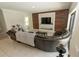 Spacious living room with a wooden accent wall and a large leather sectional couch at 2804 Alpine Meadow Ln, Kissimmee, FL 34744