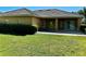 View of the backyard with a patio area surrounded by lush green grass and mature landscaping at 2981 Winding Trl, Kissimmee, FL 34746
