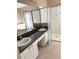 Bathroom with double sinks, a large mirror, tiled floors and a glass enclosed shower at 2981 Winding Trl, Kissimmee, FL 34746