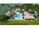 Aerial view of the community pool and clubhouse with lush landscaping and lake view at 2981 Winding Trl, Kissimmee, FL 34746