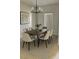 Modern dining room featuring a wooden table with six chairs and a contemporary chandelier at 2981 Winding Trl, Kissimmee, FL 34746