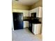 Functional kitchen featuring white cabinetry, black appliances, and durable tile flooring at 2981 Winding Trl, Kissimmee, FL 34746