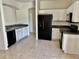 Bright kitchen features white cabinets, black appliances, and tiled floors at 2981 Winding Trl, Kissimmee, FL 34746