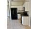 Features include white cabinets, black appliances, and tiled floors at 2981 Winding Trl, Kissimmee, FL 34746