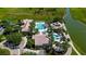 Aerial view of the community pool, hot tub, and clubhouse surrounded by lush tropical landscaping at 2981 Winding Trl, Kissimmee, FL 34746