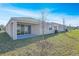 Backyard view of home with covered patio and newly planted tree at 2985 Gavin Sky Dr, Kissimmee, FL 34744