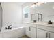 Bright bathroom featuring a soaking tub, dual vanities, and modern fixtures at 2985 Gavin Sky Dr, Kissimmee, FL 34744