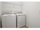 Laundry room with a new white washer and dryer and wire shelf above at 2985 Gavin Sky Dr, Kissimmee, FL 34744