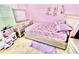A cute pink bedroom features a unicorn bedspread, matching rug, and a decorative dresser with mirror at 3082 Royal Tern Dr, Winter Haven, FL 33881