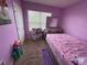 A pink bedroom with a window offers a cozy space with a twin bed and a small play area at 3082 Royal Tern Dr, Winter Haven, FL 33881