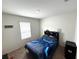 Bedroom showing a bed with blue accents, window, and a cabinet in the corner at 3082 Royal Tern Dr, Winter Haven, FL 33881