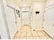 A tiled hallway features multiple doors and neutral colors, providing a clean and functional transition space at 3082 Royal Tern Dr, Winter Haven, FL 33881