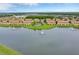 Aerial view of a lakefront townhome community featuring a swimming pool and fountains in the lake at 3102 Ashland N Ln # 3152, Kissimmee, FL 34741