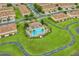 Aerial view of a resort-style community pool surrounded by lush landscaping and multiple townhomes at 3102 Ashland N Ln # 3152, Kissimmee, FL 34741