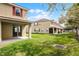 Backyard with sliding glass doors onto the patio, leading to a grassy area at 3102 Ashland N Ln # 3152, Kissimmee, FL 34741