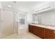 Bright bathroom with dual sinks, a shower with a glass door, and a separate soaking tub at 3102 Ashland N Ln # 3152, Kissimmee, FL 34741