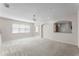Large living room with bar access, neutral carpet and multiple windows at 3102 Ashland N Ln # 3152, Kissimmee, FL 34741
