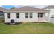 Rear exterior view of a white home with a well-maintained lawn and AC unit at 3142 Hill Point St, Minneola, FL 34715