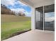 Covered patio overlooking a large, green backyard with a gentle slope and blue skies at 3142 Hill Point St, Minneola, FL 34715