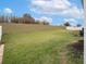 View of a large backyard featuring lush grass and a gentle slope up to a tree line at 3142 Hill Point St, Minneola, FL 34715