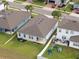 Aerial view of backyard with patio, play set, green grass, and white fence at 3142 Hill Point St, Minneola, FL 34715