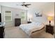 Cozy bedroom with neutral walls, ceiling fan, and a large window, creating a serene and inviting atmosphere at 3142 Hill Point St, Minneola, FL 34715
