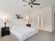 Tranquil bedroom featuring a comfortable bed, neutral decor, and access to an ensuite bathroom for added privacy at 3142 Hill Point St, Minneola, FL 34715