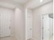 Hallway featuring neutral walls and tile flooring, leading to a bathroom with a shower at 3142 Hill Point St, Minneola, FL 34715