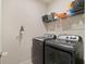 Laundry room with modern, front-load washer and dryer and wire shelving at 3142 Hill Point St, Minneola, FL 34715