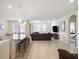 Open-concept living room and kitchen with a large island, stainless steel appliances, and modern finishes at 3142 Hill Point St, Minneola, FL 34715