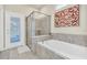 This bathroom features white cabinets, grey floors and shower, a soaking tub, and a glass-door shower at 3624 Lily Ln, Davenport, FL 33897