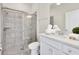 Modern bathroom with a glass-enclosed shower, white vanity, and neutral tile at 3624 Lily Ln, Davenport, FL 33897