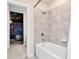 Bathroom featuring a shower-tub combo with tiled walls and a view into a themed bedroom at 3624 Lily Ln, Davenport, FL 33897