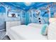 Bright themed bedroom with 'Frozen' mural, twin beds, modern dresser and decor at 3624 Lily Ln, Davenport, FL 33897
