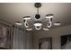 A unique chandelier with multiple illuminated rings adds a modern, stylish touch to the bedroom at 3624 Lily Ln, Davenport, FL 33897