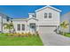Charming two-story home with landscaped front yard and a two-car garage, painted in light gray at 3624 Lily Ln, Davenport, FL 33897