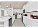 Modern kitchen featuring white cabinets, stainless steel appliances, and gray tile flooring at 3624 Lily Ln, Davenport, FL 33897
