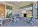 This covered patio features an outdoor kitchen, lounge seating, and a view of the screened-in pool at 3624 Lily Ln, Davenport, FL 33897