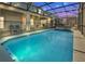 Outdoor pool, hot tub, and screened-in patio area lit up at dusk, great for relaxing in Florida at 3624 Lily Ln, Davenport, FL 33897