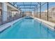 Long pool with a hot tub, all within a screened-in enclosure featuring string lights at 3624 Lily Ln, Davenport, FL 33897