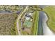 Aerial view of community amenities including a pool, tennis courts and shuffleboard courts surrounded by lakes at 3840 Wood Thrush Dr, Kissimmee, FL 34744