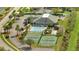 An aerial view of the community center with tennis courts and a pool surrounded by palm trees at 3840 Wood Thrush Dr, Kissimmee, FL 34744
