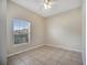 This is a bright bedroom with tile floors, a window with blinds and a ceiling fan at 3840 Wood Thrush Dr, Kissimmee, FL 34744