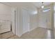 View of the entryway with light beige tile and a front door with decorative glass, plus a laundry room entry at 3840 Wood Thrush Dr, Kissimmee, FL 34744
