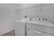 A white washer and dryer are visible in the laundry room with metal shelving for storage at 3840 Wood Thrush Dr, Kissimmee, FL 34744