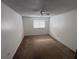 An empty bedroom featuring neutral carpet, a ceiling fan, and a bright window at 404 Banyon Tree Cir # 202, Maitland, FL 32751