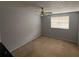 The bedroom has a simple window, carpet flooring, ceiling fan, and a neutral paint palette at 404 Banyon Tree Cir # 202, Maitland, FL 32751